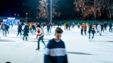 Şehir Parkı Buz Pisti 'nde buz pateni yapan insanları izliyoruz. 