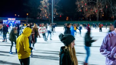 Şehir Parkı Buz Pisti 'nde buz pateni yapan insanları izliyoruz. 