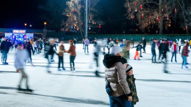 Şehir Parkı Buz Pisti 'nde buz pateni yapan insanları izliyoruz. 