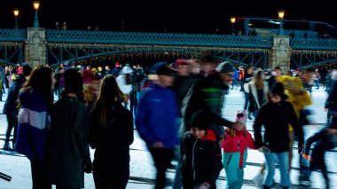 Şehir Parkı Buz Pisti 'nde buz pateni yapan insanları izliyoruz. 