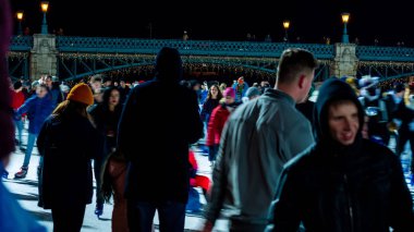 Şehir Parkı Buz Pisti 'nde buz pateni yapan insanları izliyoruz. 