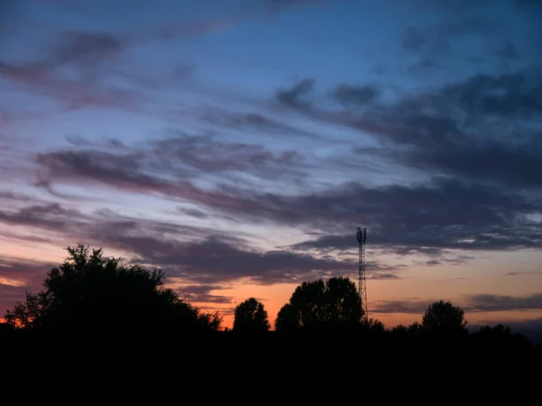 Blick über einen wunderschönen Sonnenuntergang hinter einem Funkantennenmast. — Stockfoto