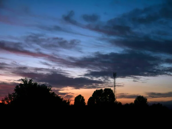 Blick über einen wunderschönen Sonnenuntergang hinter einem Funkantennenmast. — Stockfoto