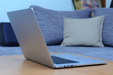 Oturma odasındaki ofis ortamındaki bir masada dizüstü bilgisayarda görüntüle.