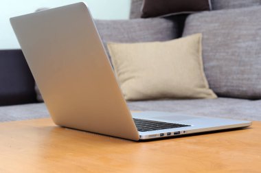 Oturma odasındaki ofis ortamındaki bir masada dizüstü bilgisayarda görüntüle.