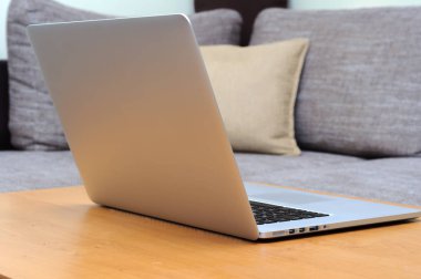 Oturma odasındaki ofis ortamındaki bir masada dizüstü bilgisayarda görüntüle.