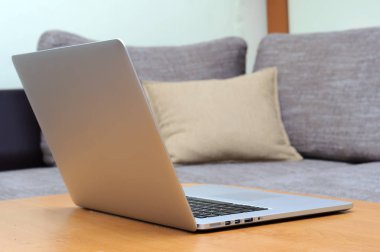 Oturma odasındaki ofis ortamındaki bir masada dizüstü bilgisayarda görüntüle.