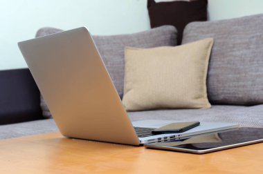 Bilgisayardan, akıllı telefondan ve oturma odasındaki ofis ortamındaki bir masada duran tabletten görüntüle.