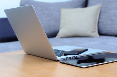 Bilgisayardan, akıllı telefondan ve oturma odasındaki ofis ortamındaki bir masada duran tabletten görüntüle.