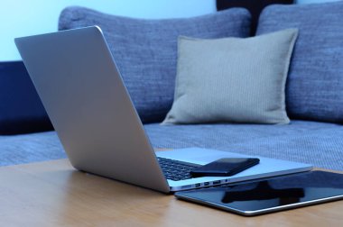 Bilgisayardan, akıllı telefondan ve oturma odasındaki ofis ortamındaki bir masada duran tabletten görüntüle.