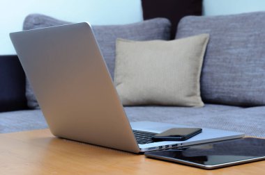 Bilgisayardan, akıllı telefondan ve oturma odasındaki ofis ortamındaki bir masada duran tabletten görüntüle.