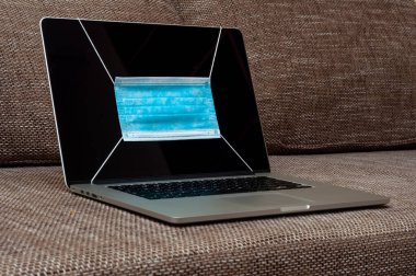 Bilgisayar ekranında Coronavirus gibi grip ve diğer hastalıklara karşı tıbbi maske korumasına bakın.