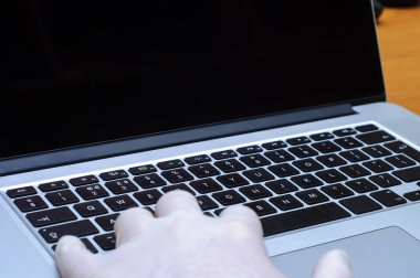 Grip veya koronavirüs gibi hastalıklara karşı eldiven giyerken dizüstü bilgisayarda yazan doktorlara bakın..