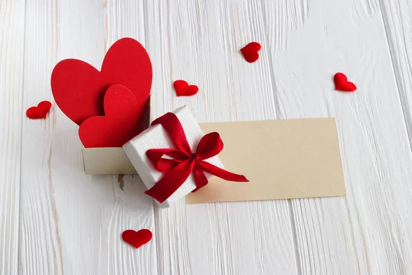 Gift box with a red heart inside on a white old wooden table. Va — Stock Photo, Image
