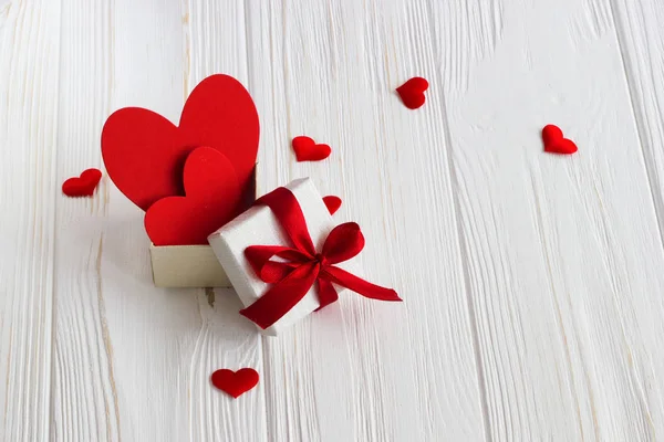De doos van de gift met een rood hart binnen op een witte oude houten tafel. VA — Stockfoto
