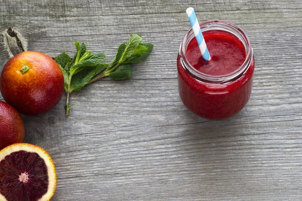 Smoothie vermelho com laranjas vermelhas, maçãs, romã e hortelã — Fotografia de Stock