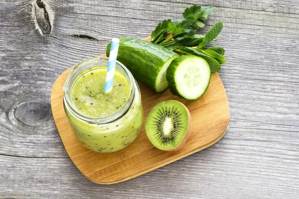 Groene smoothie met kiwi fruit, komkommer, mint en peterselie op ol Stockfoto