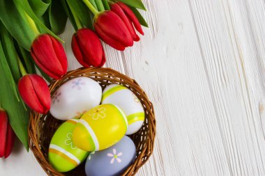 Buket kırmızı lale çiçek ile Paskalya yumurta üzerinde eski ahşap masa