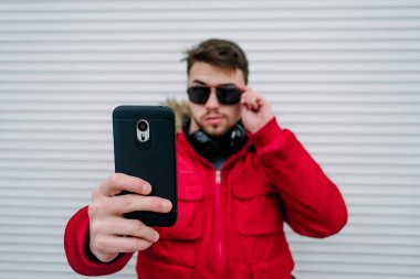Gözlüklü genç bir adam selfie yapar