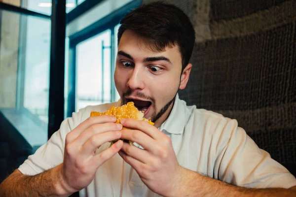 Oung ember élvezi, evés gyorsétterem, ízletes burger — Stock Fotó