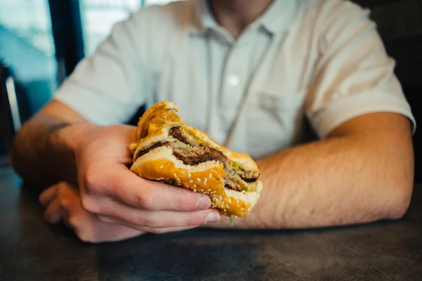 햄버거를 들고 젊은 남자의 손 — 스톡 사진