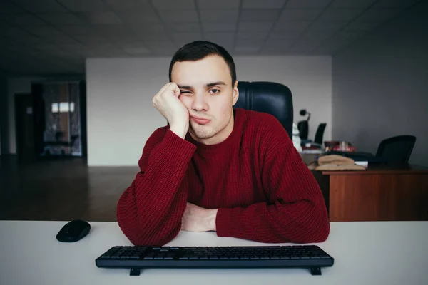Retrato de un joven cansado con la computadora. En el contexto del espacio de oficinas. La situación en la oficina — Foto de Stock