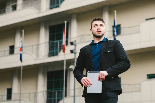 Retrato al aire libre de un joven con una Tablet PC en las manos sobre el fondo del edificio. Concepto empresarial —  Fotos de Stock