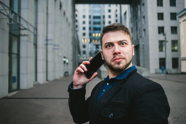 Divertido sorprendido hombre y hombre de negocios hablando por teléfono en el fondo de un paisaje urbano moderno. Concepto empresarial —  Fotos de Stock
