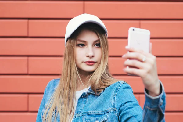 Menina em jaqueta de ganga levando selfie — Fotografia de Stock