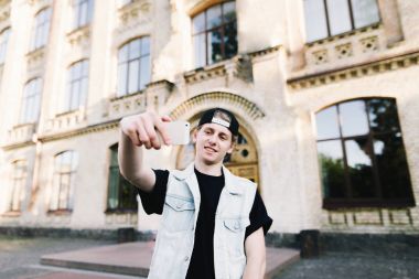 Öğrenci selfie telefon ile kampüste alır.