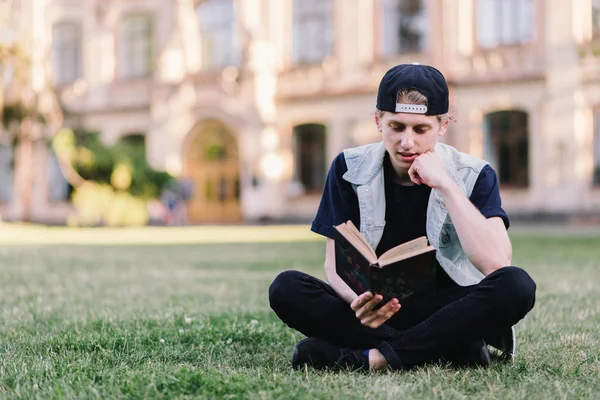 Joven estudiante leyendo libro en el campus —  Fotos de Stock