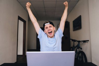 Mutlu teen sevinç ile evin odasında bilgisayar başında oturan onun ellerini kaldırdı.