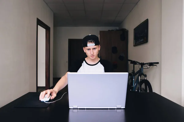 Concebido joven mirando un ordenador portátil mientras trabaja en casa . — Foto de Stock