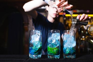 Barmen bir alkolik restoranda kokteyl yapar. Barmen kokteyl maddelerin karışımları.