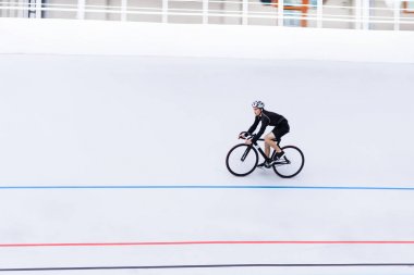 Modern velodrome bisikletle trenlerle aktif genç adam. Spor kavramı.