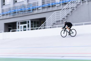 Yüksek hızda bir velodrome sürme bir bisikletçi. Eğitim bisiklet. Spor