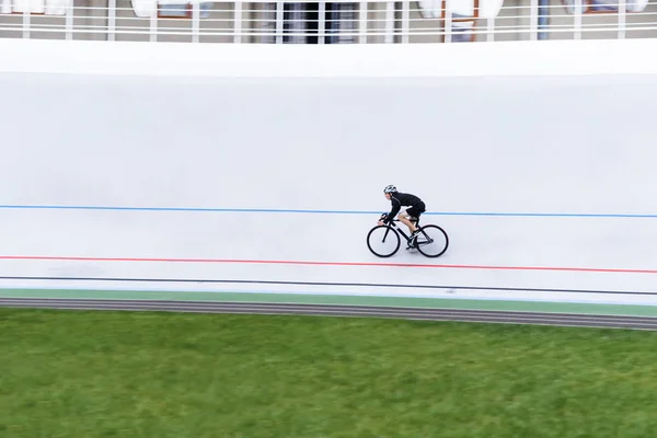 Een actieve jonge man rijdt een fiets op een wielerbaan. minimalistische foto. Sport onderwerpen. Cardio-training — Stockfoto