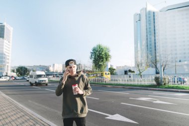 Evet ve bir bardak kahve şehir etrafında yürürken tutan bir öğrenci genç bir adamdır. Yaşam tarzı ve insanlar kavramı.