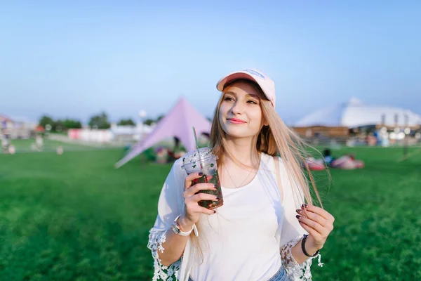 Lächelt ein schönes junges Mädchen, das über den Rasen im Park läuft und ihn genießt. Sommerkonzept. — Stockfoto