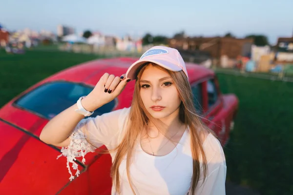 Stilvolle und schöne Mädchen posiert mit dem Auto in einem Freizeitpark. Sommerkonzept. — Stockfoto