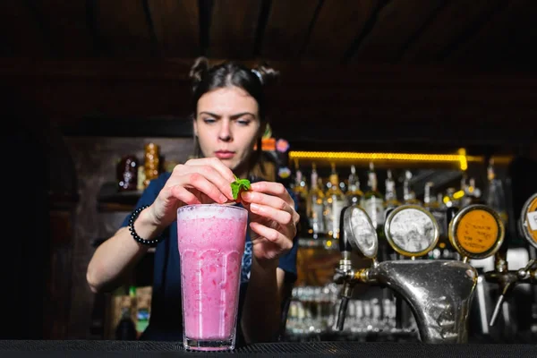 Il barista ragazza è decorato con una menta bella e rosa cocktail femminile. Bramen sta preparando un cocktail al bar . — Foto Stock