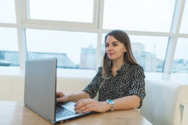 Gebe kadın serbest meslek sahibi bir dizüstü bilgisayar ile şık bir intrerer bir kafede çalışıyor. Bir dizüstü bilgisayar ile bir kafede internette güzel bir kadın oturur.