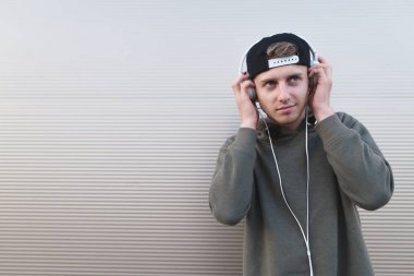 Olumlu bir öğrenci hafif bir arka plan üzerinde kulaklık programında müzik dinlemek mutludur.