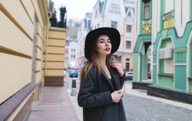 Eski güzel bir şehir çevresindeki sokaklarda yürüyen bir şık kadın sokak portresi. Şehrin yürürken kameraya şık bir kadın görünüyor