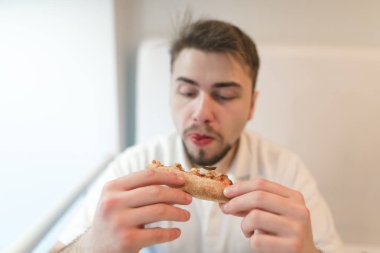 Acıktın yakından bir parça pizza elinde görünüyor ve bu yenir mi.