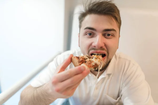 O homem come uma pizza deliciosa. Fast food para almoço . — Fotografia de Stock