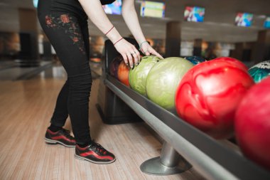 Kız atmadan önce bowling oyun için renkli bir kase seçer. Bowling oyunu.