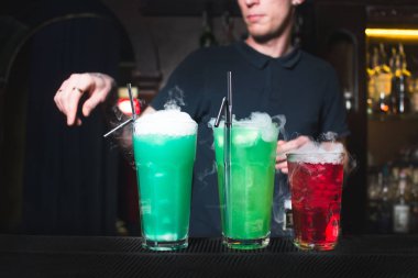 Barmen oluşturulan parlak renkli kokteyller barda sayaç. Bir barmen arka plan üzerinde alkollü kokteyller.