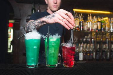 Barmen, bir gece kulübünde renkli alkollü kokteyller oluşturur. Güzel alkol.