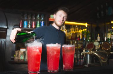 Restoran barda kokteyl kırmızı şişede alkol dökme barmen